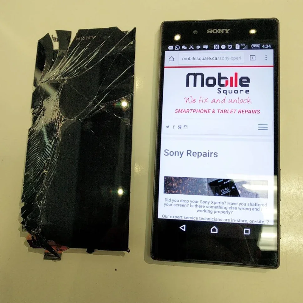 Repaired Sony smartphone next to a shattered glass screen